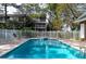 Inviting community pool with lounge chairs, surrounded by a fence and lush trees at 9920 Indian Key Trl # 29, Seminole, FL 33776