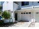 Close up of the exterior entrance with garage, porch, and a dark green front door at 9920 Indian Key Trl # 29, Seminole, FL 33776