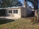 Backyard view of home and chimney surrounded by mature trees, landscaping, and patio at 9346 52Nd Way, Pinellas Park, FL 33782