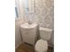 Bright bathroom features a modern vanity, toilet, and stylish leaf-patterned wallpaper at 9346 52Nd Way, Pinellas Park, FL 33782