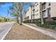 Exterior of condo building with sidewalk and treelined street on a sunny day at 1000 W Horatio St # 327, Tampa, FL 33606