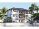 The rear exterior shows a house overlooking a waterfront with balconies and an outdoor seating area at 12155 5Th E St, Treasure Island, FL 33706