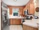 Functional kitchen space with stainless steel refrigerator, black range, and ample cabinet storage at 12402 Country White Cir, Tampa, FL 33635