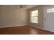 Bright living room featuring wood floors, a ceiling fan, and a large window at 13924 Morgan St, Dade City, FL 33525