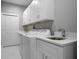 Well-equipped laundry room with a sink, storage cabinets, washer, and dryer at 1409 W Wood St, Tampa, FL 33604