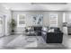 Inviting living room showcasing a gray sectional, decorative rug, modern artwork, and ample natural light at 1409 W Wood St, Tampa, FL 33604