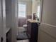 Compact bathroom with a wooden vanity, tiled floor, toilet, and window at 14124 Plum Ln, Hudson, FL 34667