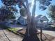 View of house exterior behind a chain link fence, complemented by a prominent tree at 14124 Plum Ln, Hudson, FL 34667