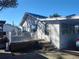 Rear exterior with a small deck, steps, and a partial view of a car, under a blue sky at 14124 Plum Ln, Hudson, FL 34667