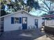 Garage exterior with two blue doors, a window with shutters, and a concrete area in front, for parking at 14124 Plum Ln, Hudson, FL 34667