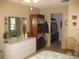 Bedroom with dresser and mirror with a view into the bathroom and closet at 1440 Hales Hollow Dr, Dunedin, FL 34698