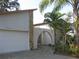 Home exterior featuring attached garage, tropical landscaping, and stucco walls at 1440 Hales Hollow Dr, Dunedin, FL 34698