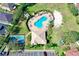 Aerial view of community pool, tennis courts, parking, and clubhouse surrounded by lush greenery in a residential neighborhood at 1604 Mira Lago Cir, Ruskin, FL 33570