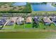 Overhead view of a waterfront home showcasing lush greenery, a manicured lawn, and a serene lake backdrop at 1604 Mira Lago Cir, Ruskin, FL 33570