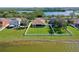 Aerial view of a backyard with a white fence, green lawn, and lake views at 1604 Mira Lago Cir, Ruskin, FL 33570