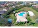 Aerial shot of a community pool with a clubhouse, tennis court, lush landscaping, and manicured lawns at 1604 Mira Lago Cir, Ruskin, FL 33570