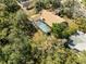 Aerial view of a home featuring an enclosed pool and mature trees at 18836 Autumn Lake Blvd, Hudson, FL 34667