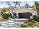 Exterior side view of home with a front-entry two car garage and well-maintained lawn at 18836 Autumn Lake Blvd, Hudson, FL 34667