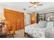 Main bedroom featuring a four-poster bed, wood accents, neutral tones, and a view of the screened pool area at 18836 Autumn Lake Blvd, Hudson, FL 34667