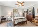 Cozy main bedroom featuring a four-poster bed, vintage dresser, wood rocking chair, and natural light at 18836 Autumn Lake Blvd, Hudson, FL 34667