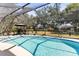 Relaxing screened pool area with outdoor seating, lush landscaping, and a clear view of the surrounding greenery at 18836 Autumn Lake Blvd, Hudson, FL 34667