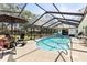 Inviting screened pool area with lounge chairs, outdoor seating, and lush landscaping at 18836 Autumn Lake Blvd, Hudson, FL 34667