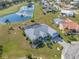 Stunning aerial view of a home with a screened pool, golf course frontage and water view at 2011 Captiva Ct, Sun City Center, FL 33573