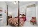 A cozy bedroom featuring a four-poster bed, window, and chair at 2011 Captiva Ct, Sun City Center, FL 33573