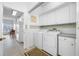 Laundry room with white cabinetry, a washer and dryer set, and access to the kitchen at 2011 Captiva Ct, Sun City Center, FL 33573