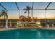 Inviting screened pool with rock waterfall feature and mature landscaping at 2011 Captiva Ct, Sun City Center, FL 33573