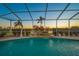 A screened-in pool featuring a tranquil waterfall and lush tropical landscaping at 2011 Captiva Ct, Sun City Center, FL 33573