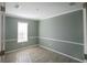 Cozy bedroom featuring light gray walls, white trim, and a window offering ample natural light at 204 El Prado, North Port, FL 34287