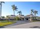 Inviting clubhouse entrance with covered parking for golf carts and lush tropical landscaping at 204 El Prado, North Port, FL 34287