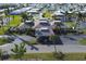 An aerial view of the community clubhouse and amenities, with a green lawn and surrounding palm trees at 204 El Prado, North Port, FL 34287