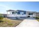 Charming blue and white home with a covered porch and carport, perfect for enjoying the outdoors at 204 El Prado, North Port, FL 34287