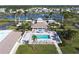 Community clubhouse with a pool area, surrounded by palm trees, sun loungers, and seating at 204 El Prado, North Port, FL 34287