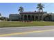 Community clubhouse featuring arched entrances, a well-maintained lawn, and palm trees at 2330 Ecuadorian Way # 10, Clearwater, FL 33763