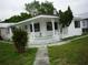 Inviting home showcasing a covered front porch with intricate white railings and landscaping at 2414 E 8Th Ave, Tampa, FL 33605