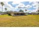 Spacious backyard with lush grass, palm trees, and a screened-in lanai at 29447 Schinnecock Hills Ln, San Antonio, FL 33576