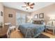 Cozy bedroom featuring a ceiling fan, shuttered window and an ornate queen-sized bed at 29447 Schinnecock Hills Ln, San Antonio, FL 33576