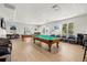 Bright billiard room with two pool tables, comfortable seating, and plenty of space for recreation at 29447 Schinnecock Hills Ln, San Antonio, FL 33576