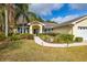 Charming home entrance with a decorative portico and lush landscaping at 29447 Schinnecock Hills Ln, San Antonio, FL 33576