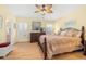 A relaxing main bedroom with a ceiling fan and large bed, and a view into the main bathroom at 29447 Schinnecock Hills Ln, San Antonio, FL 33576