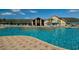 Large swimming pool with inviting blue water and a backdrop of a beautiful community center building at 29447 Schinnecock Hills Ln, San Antonio, FL 33576