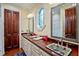 Bathroom with a wood vanity, decorative sinks, two mirrors, and a small window at 3005 S Miller Rd, Valrico, FL 33596