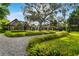 Stately stone residence featuring mature trees, a circular drive, and lush landscaping at 3005 S Miller Rd, Valrico, FL 33596