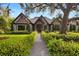 Charming home featuring a stone facade, timber accents, mature landscaping, and a stone walkway at 3005 S Miller Rd, Valrico, FL 33596