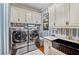 Laundry room with white cabinets, stainless steel washer and dryer, and blue accents at 3005 S Miller Rd, Valrico, FL 33596