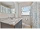 Cozy bathroom with single sink, granite counters, and a shower-tub combo at 3213 W Cass St, Tampa, FL 33609