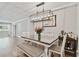 Dining room with modern chandelier, table with bench and chairs, and hardwood floors at 3213 W Cass St, Tampa, FL 33609